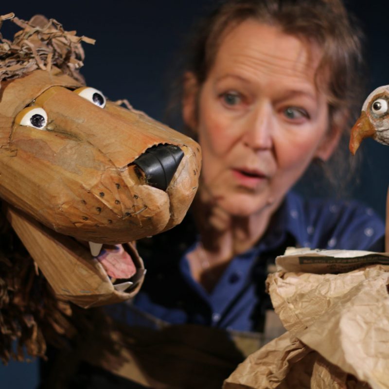 Puppeteer with cardboard lion and bird