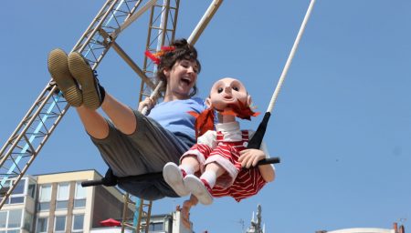 Puppet and performer on a swing