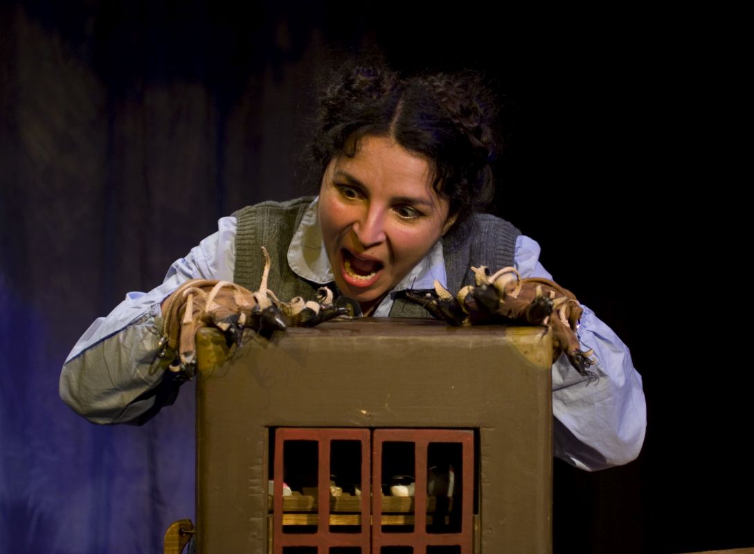 Female theatre performer operating mouse finger puppet