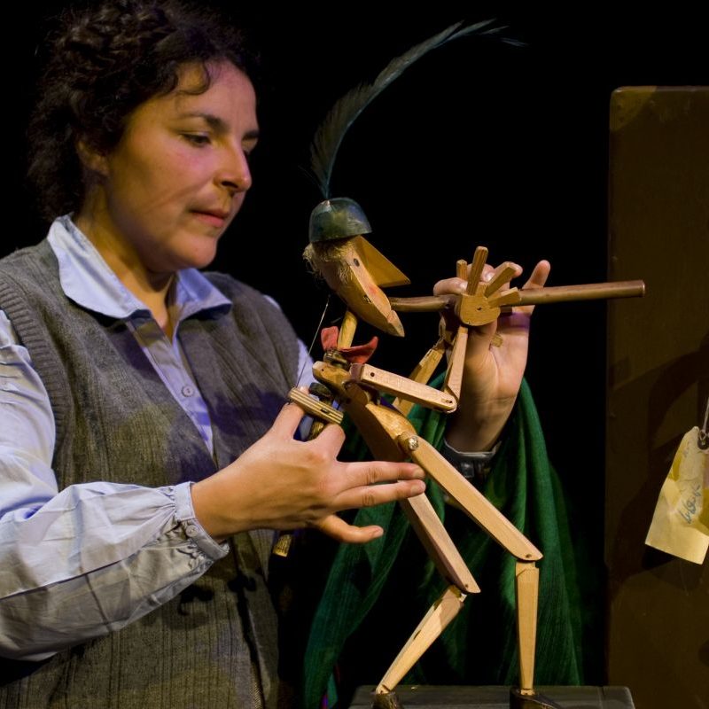Female theatre performer operating wooden Pied Piper puppet
