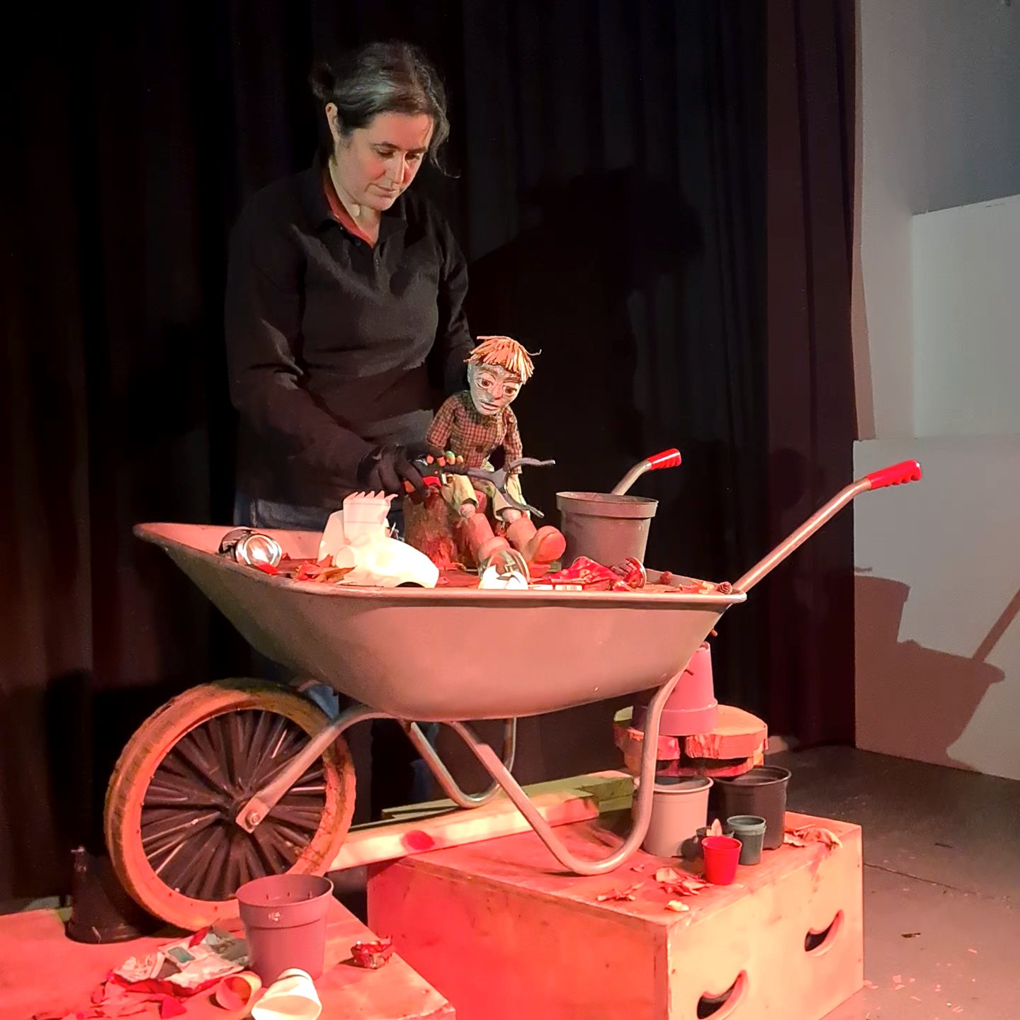 
pict moving parts.jpg
A puppeteer with an expressive face performs on stage with a spindly-limbed puppet and a large mechanical fly over a vintage wooden trunk.  lion lukas.jpg
A performer wearing a textured lion mask with a straw mane and glowing orange eyes stands against a vibrant, patchwork jungle backdrop.  WheelBarrow Still.jpg
A puppeteer manipulates a wide-eyed puppet sitting in a wheelbarrow filled with gardening props and autumn leaves on a stage.